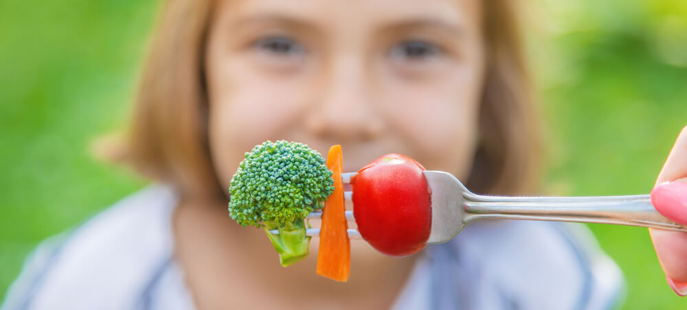 Child Eats Vegetables Broccoli and Carrots