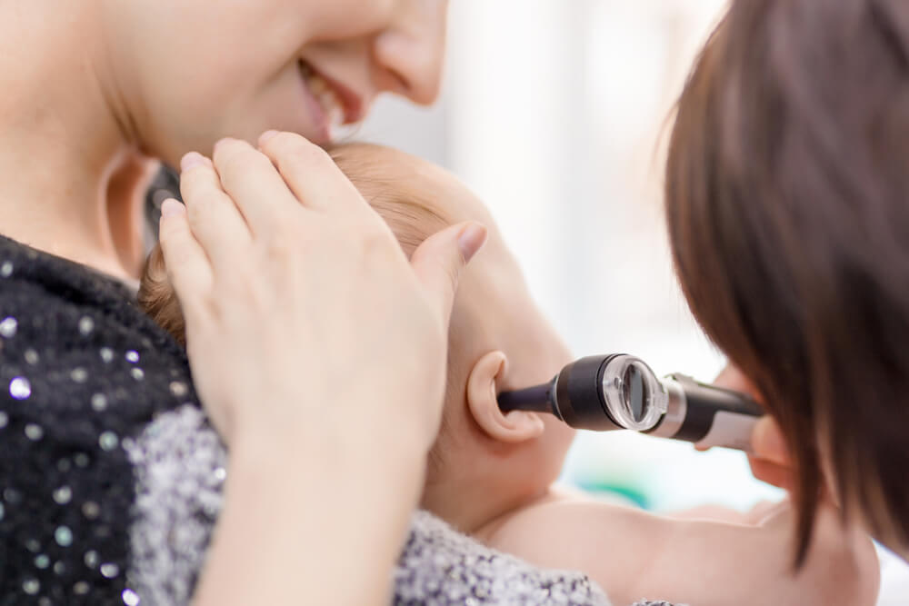 Doctor Examining Childs Ear With Otoscope.