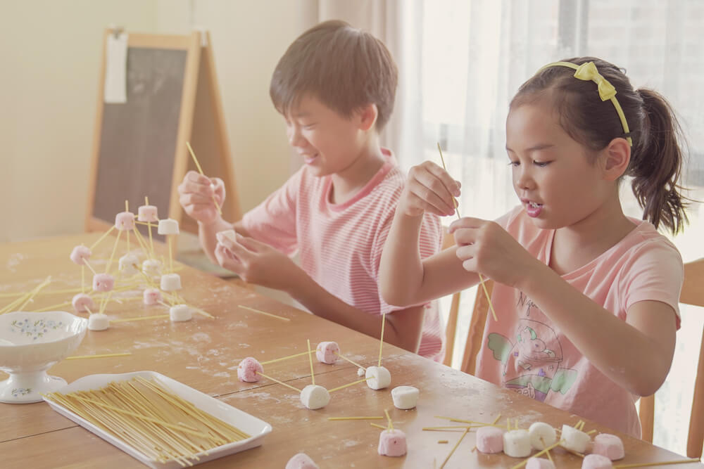 Children Building Tower With Spaghetti and Marshmallow Learning Remotely at Home