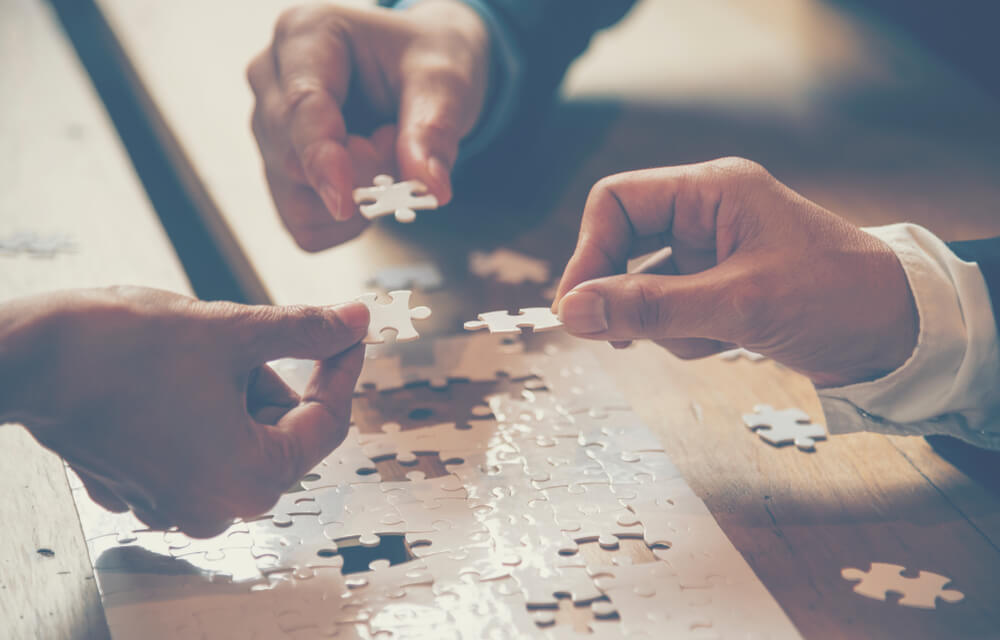 People Solving a Puzzle Close Up