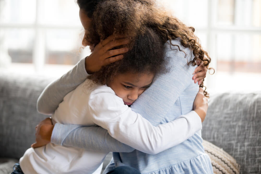 A mother is hugging and supporting her sad and disappointed daughter.