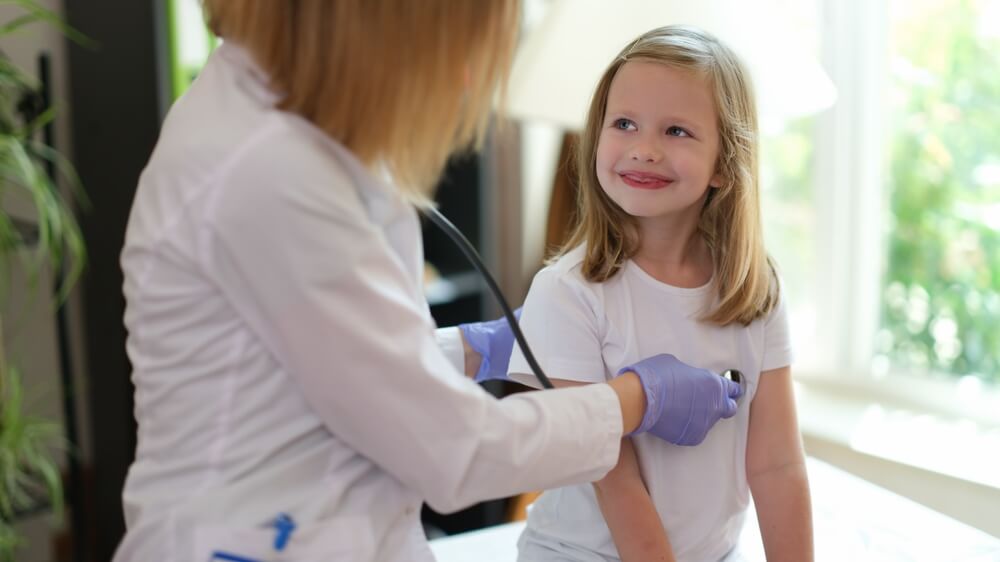 Young Female Patient Smiles at Doctor at Medical Examination