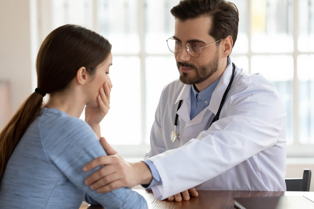 Close Up Caring Doctor Therapist Wearing White Uniform With Stethoscope Touching Frustrated Patient Shoulder