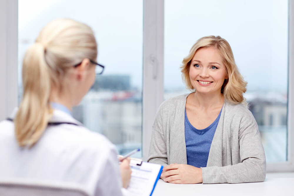 Smiling Doctor and Woman Meeting at Hospital