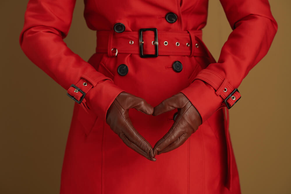 Hello November. Closeup On Middle Aged Woman With Leather Gloves Showing Heart Shaped Hands Isolated On Beige.