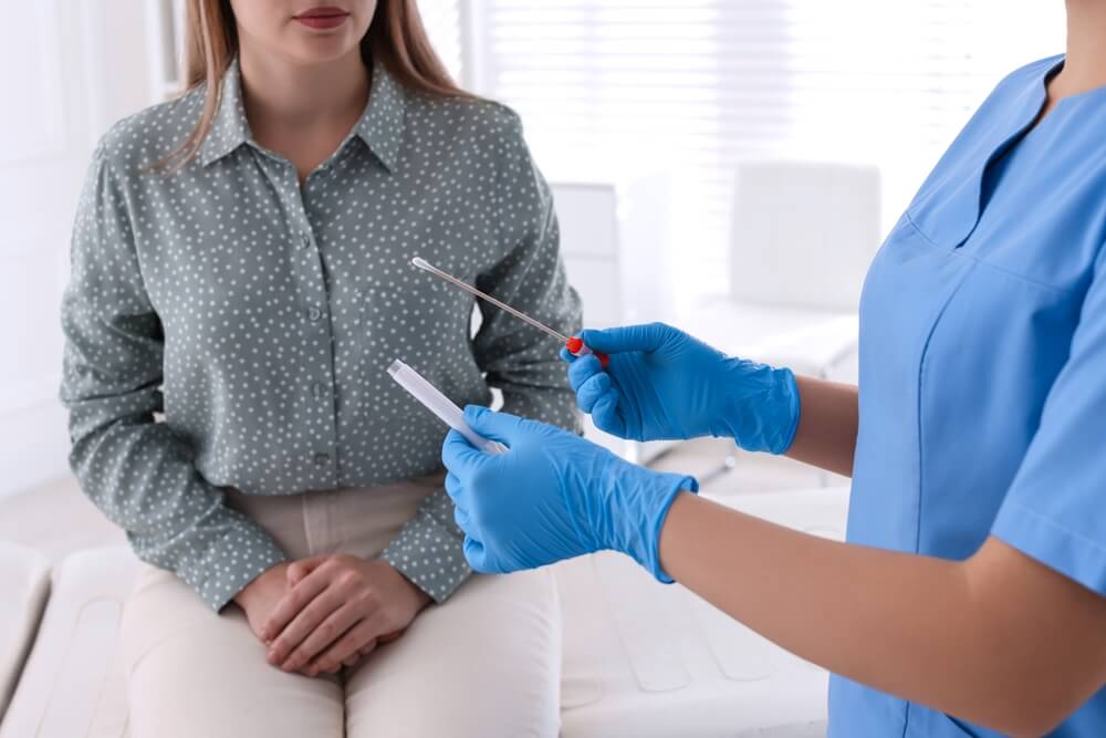 Doctor Taking Sample for STD Testing From Woman in Clinic