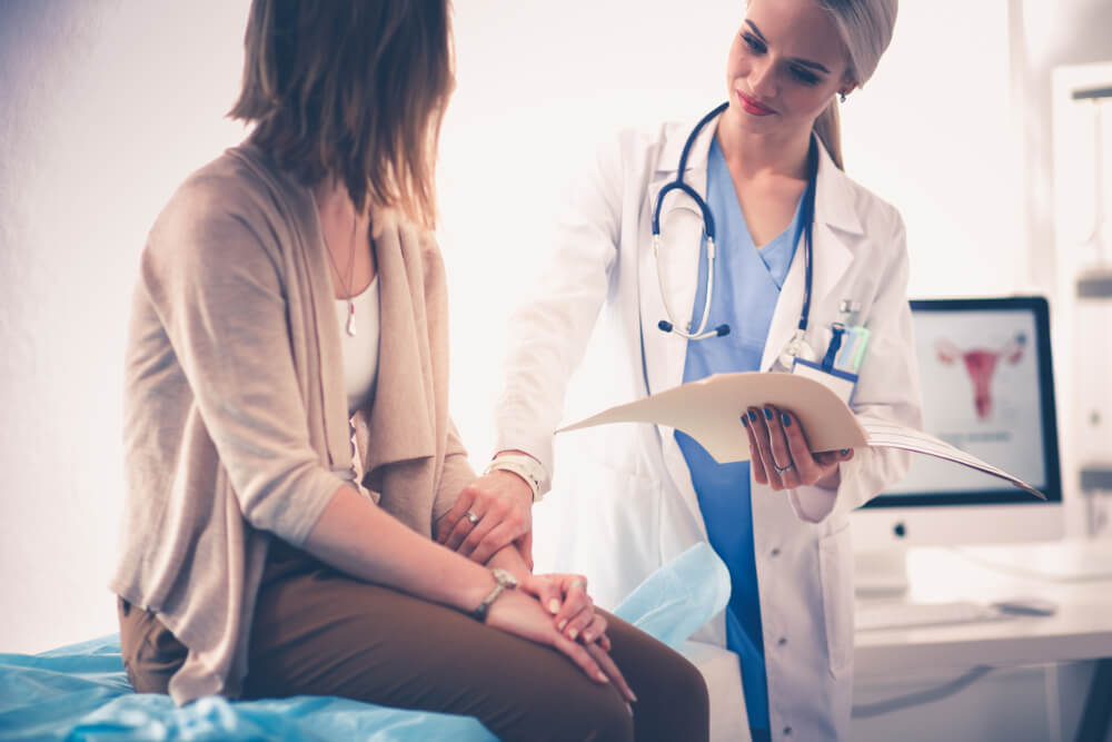 Doctor and Patient Discussing Something While Sitting at the Table 