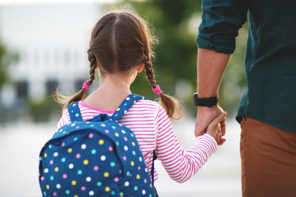 First Day at School. Father Leads a Little Child School Girl in First Grade