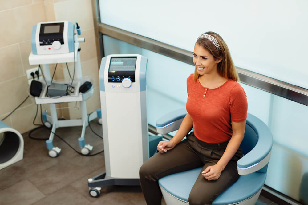 Happy Woman During Electromagnetic Procedure for Urinary Incontinence at Medical Clinic.